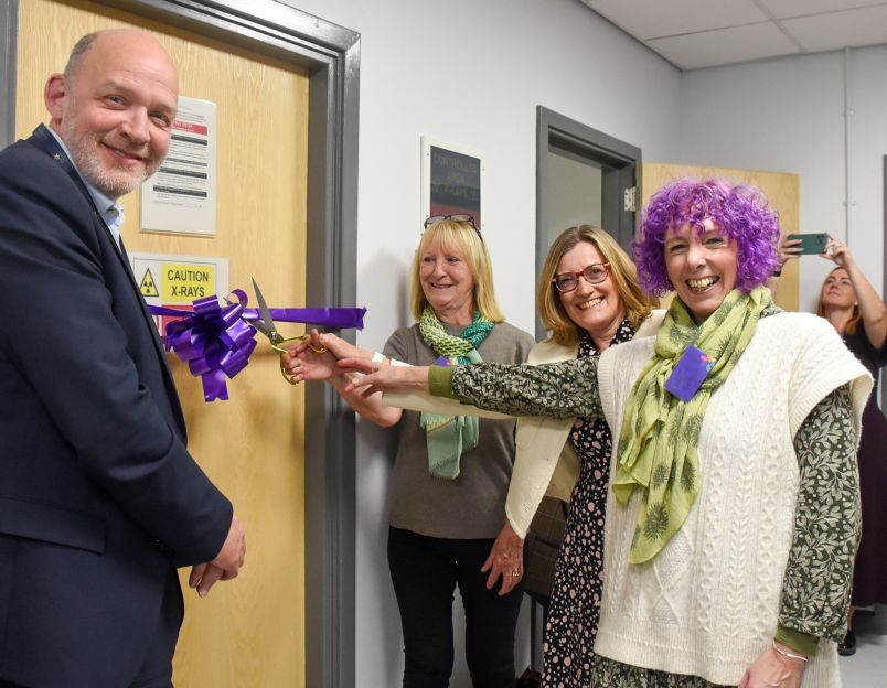 Smiling staff cutting the ribbon to the new breast screening room