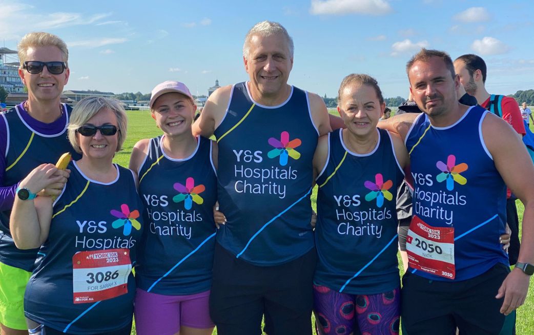 Runners smiling in charity running vests