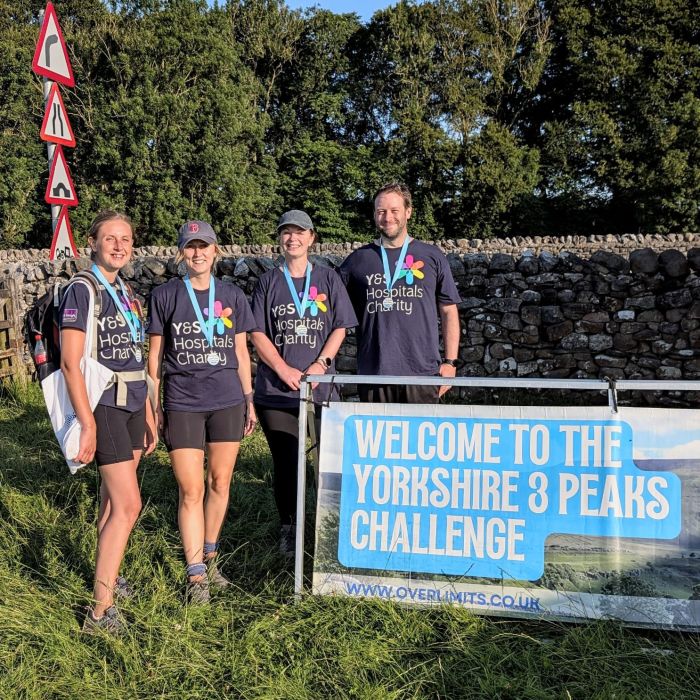 4 people standing by the welcome sign for the Yorkshire Peaks Challenge