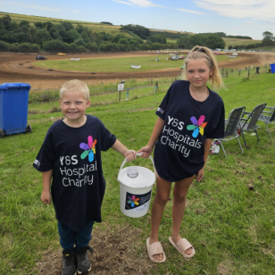 two children wearing York and scarborough hospital charity t-shirts holding collecting buckets