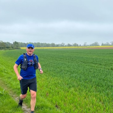 Simon running through a field in one of his past challenge events