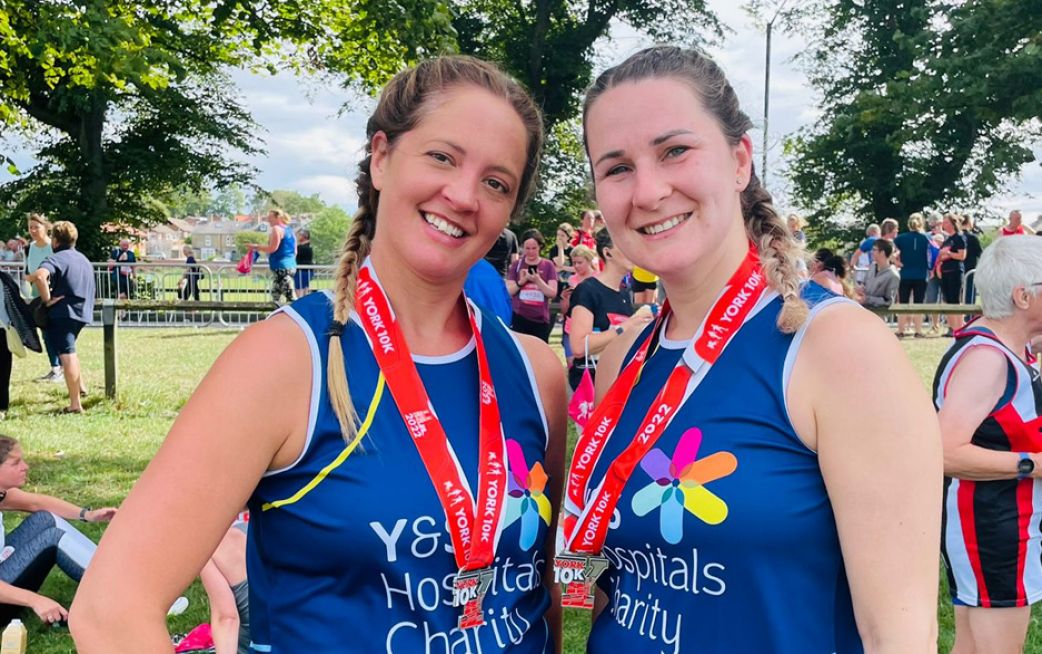 Two runners smiling after a race with their medals