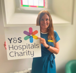 Sally holing York & Scarborough Hospitals Charity Sign