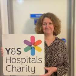 Sarah holing a York & Scarborough Hospitals Charity sign