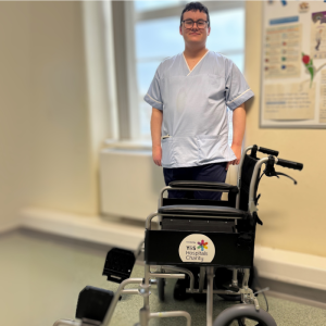 Staff member standing with wheelchair